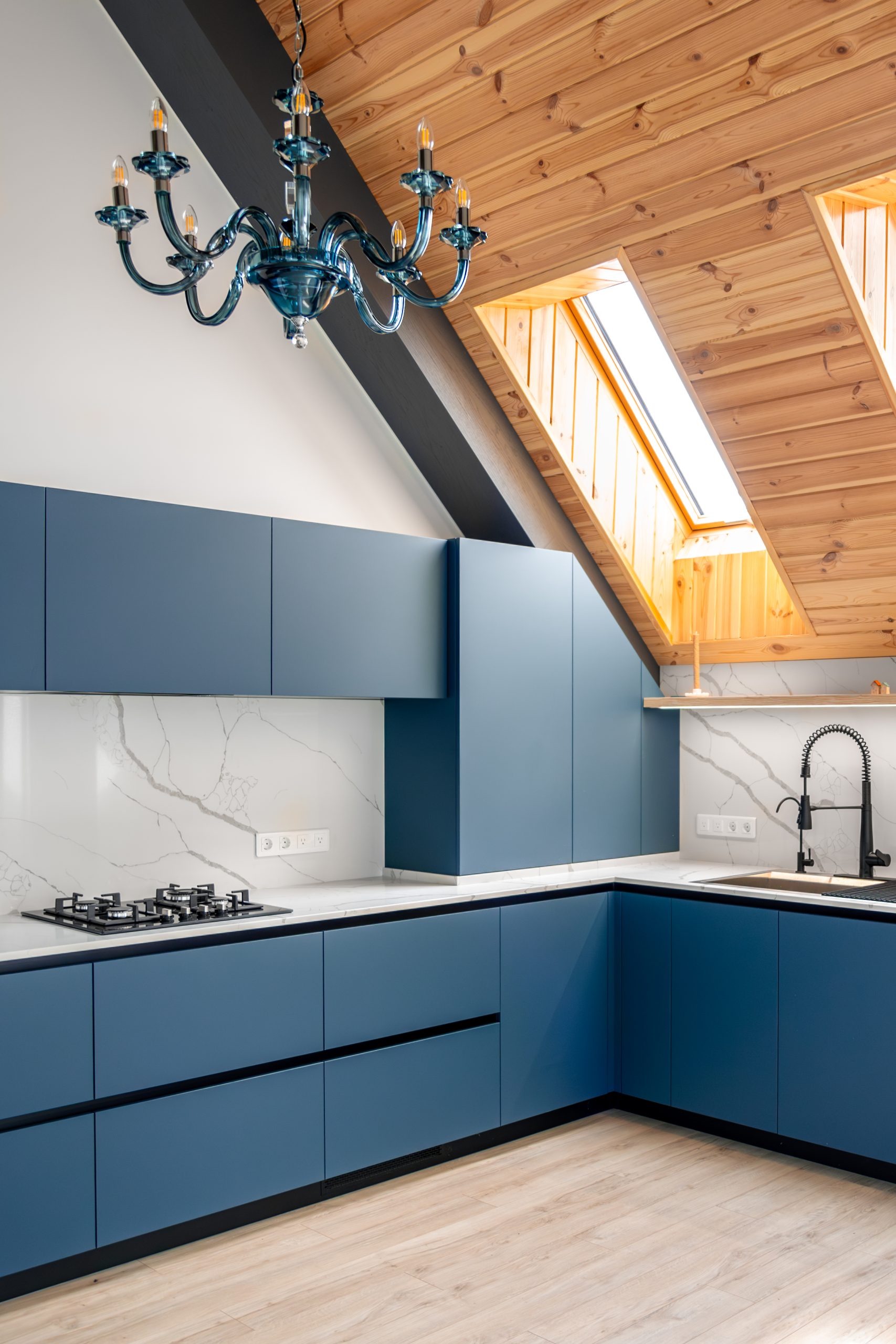 blue kitchen fronts. glass chandelier. attic light
